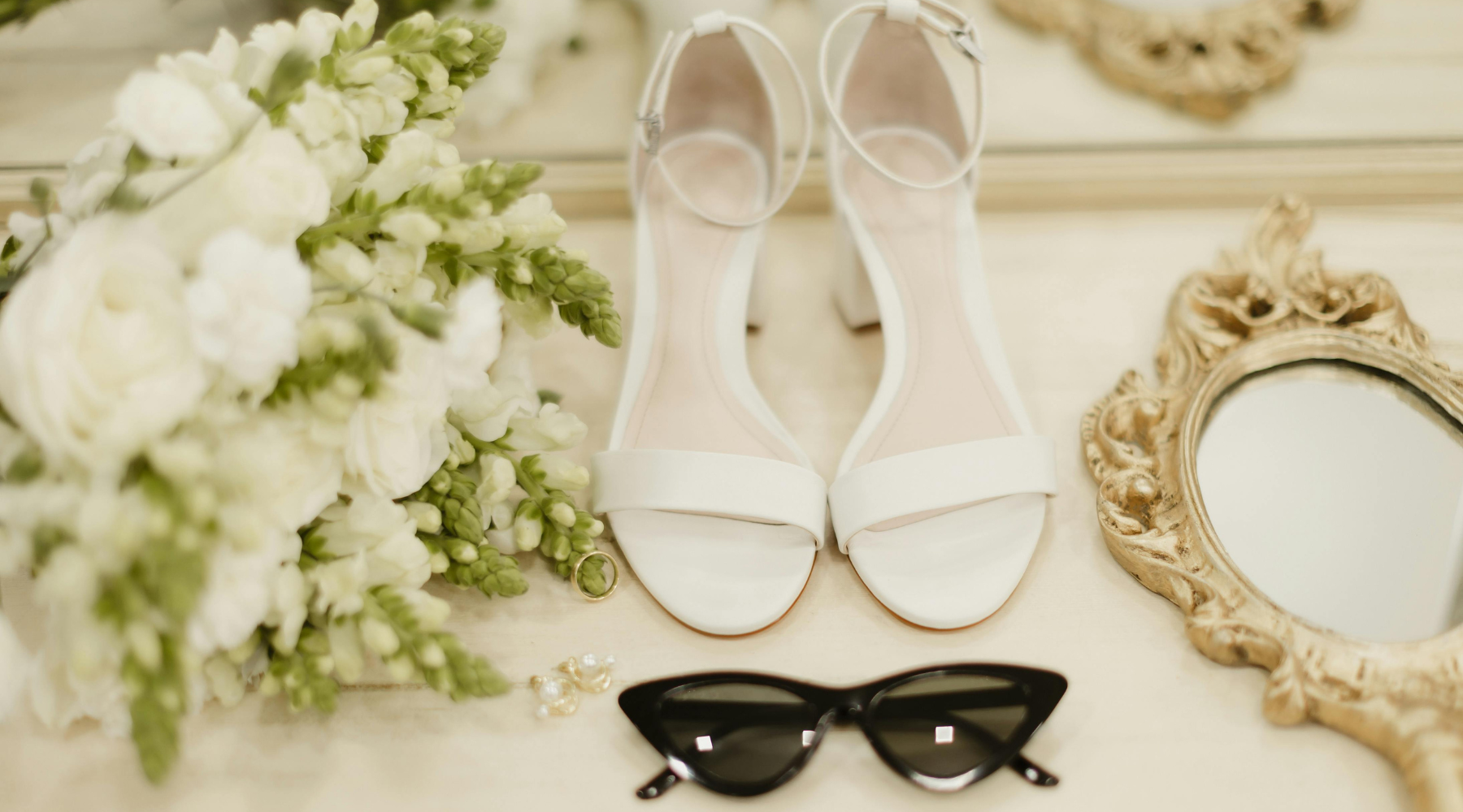 flowers, white sandals for a wedding, chic sunglasses and a golden hand mirror